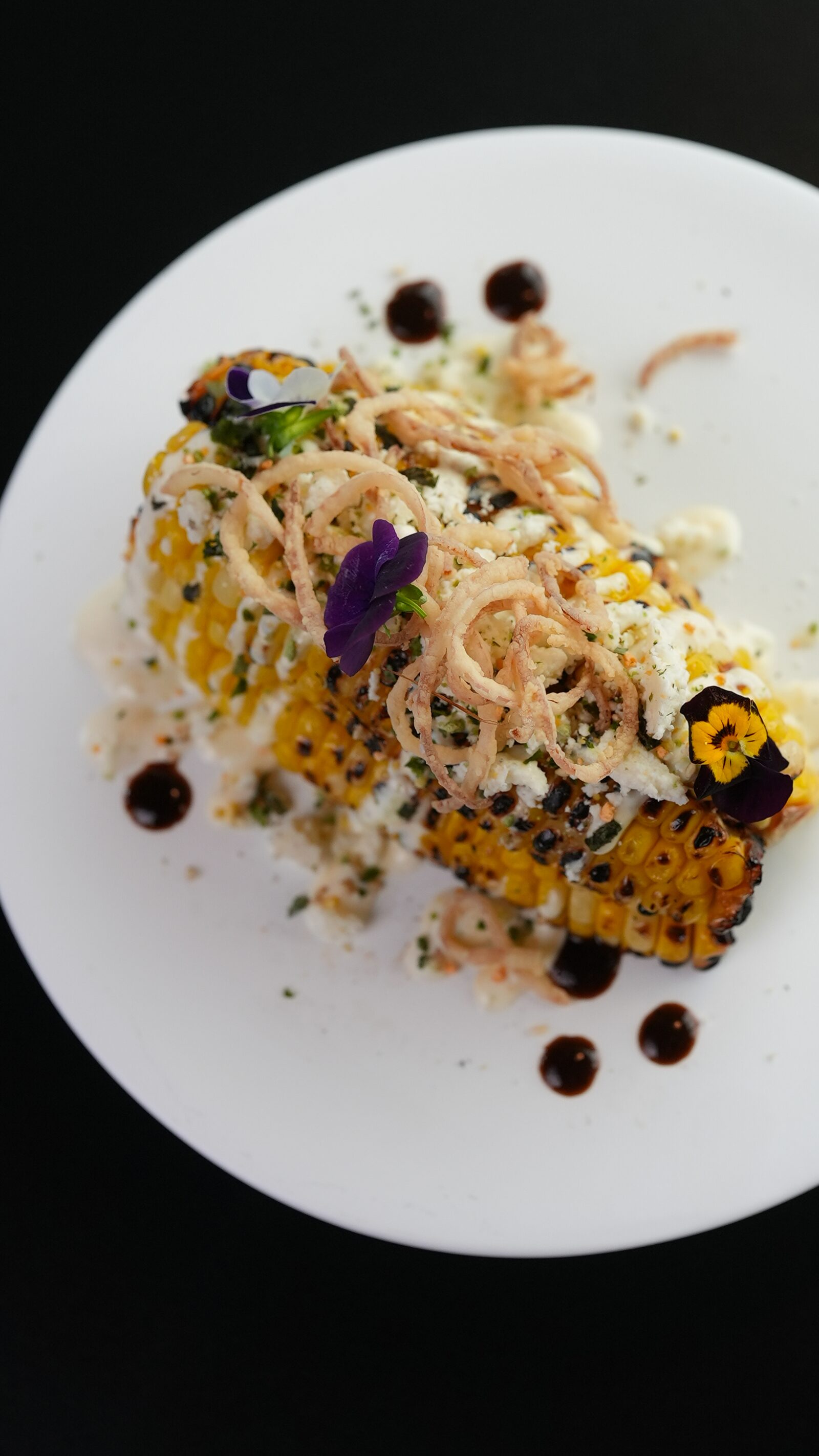 Japanese street corn with chili crema and crispy onions