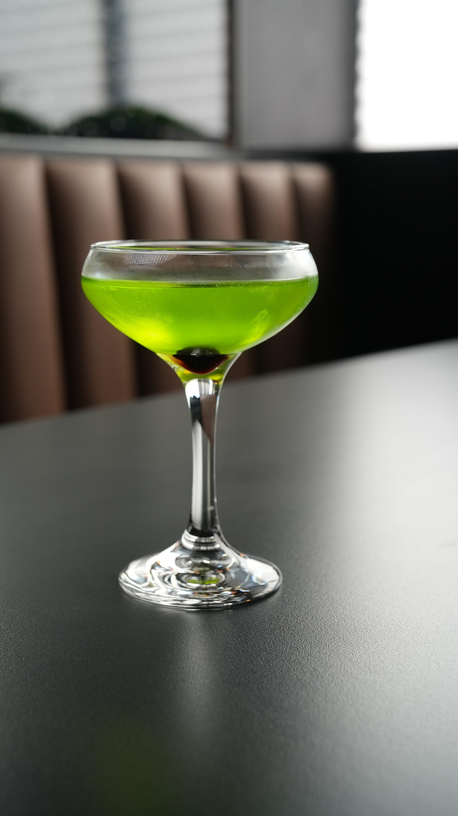 Bright green matcha martini in a coupe glass