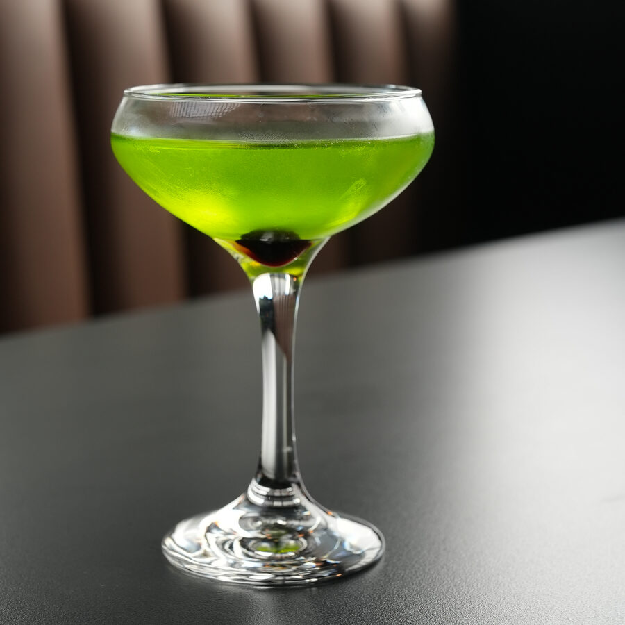 Bright green matcha cocktail in a coupe